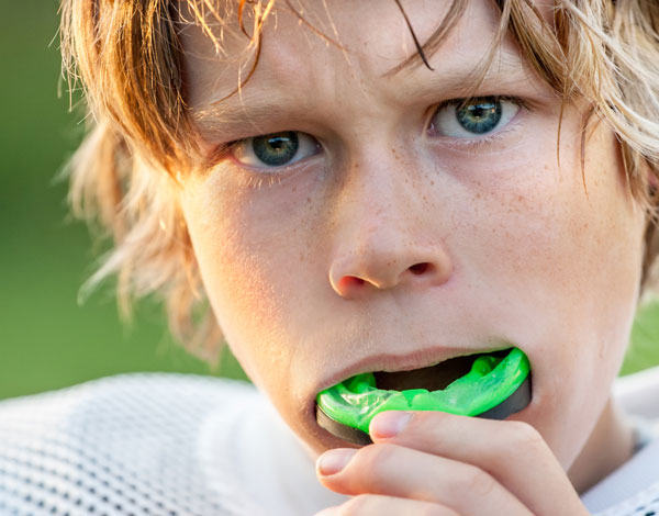 boy putting green mouthpice in his mouth